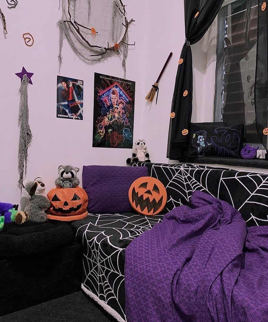 Room decorated with Halloween-themed items, spiderwebs, and purple covers