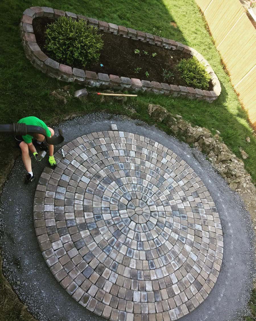 Aerial view of circular brick patio and gardener at work