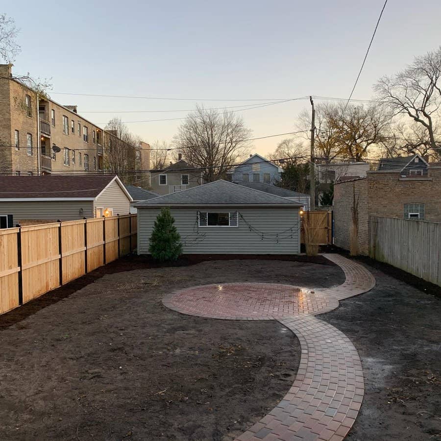 Twilight over a backyard with new circular patio and path