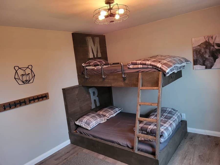 Rustic wood bunk bed with plaid bedding, metal pipe railings, and a cozy cabin vibe perfect for a boys’ shared bedroom