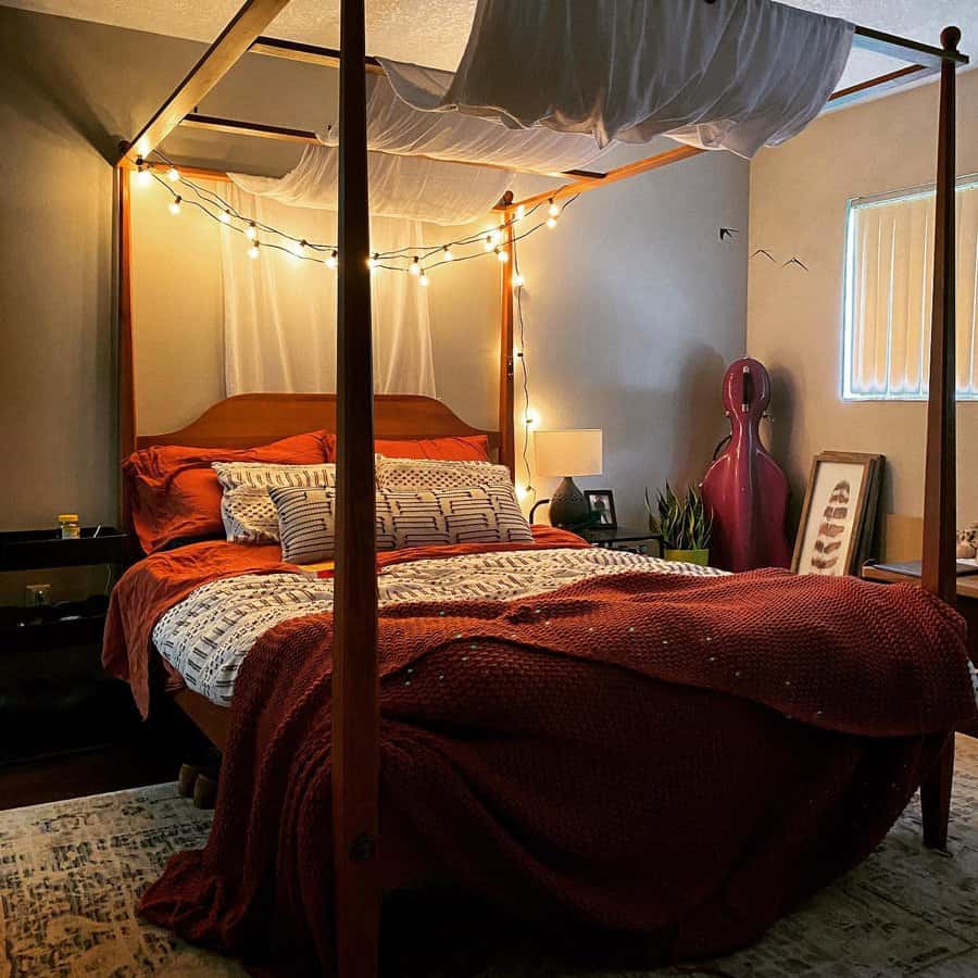 Cozy rustic canopy bed with warm-toned bedding, string lights, and draped fabric, creating a soft, inviting, and intimate bedroom atmosphere