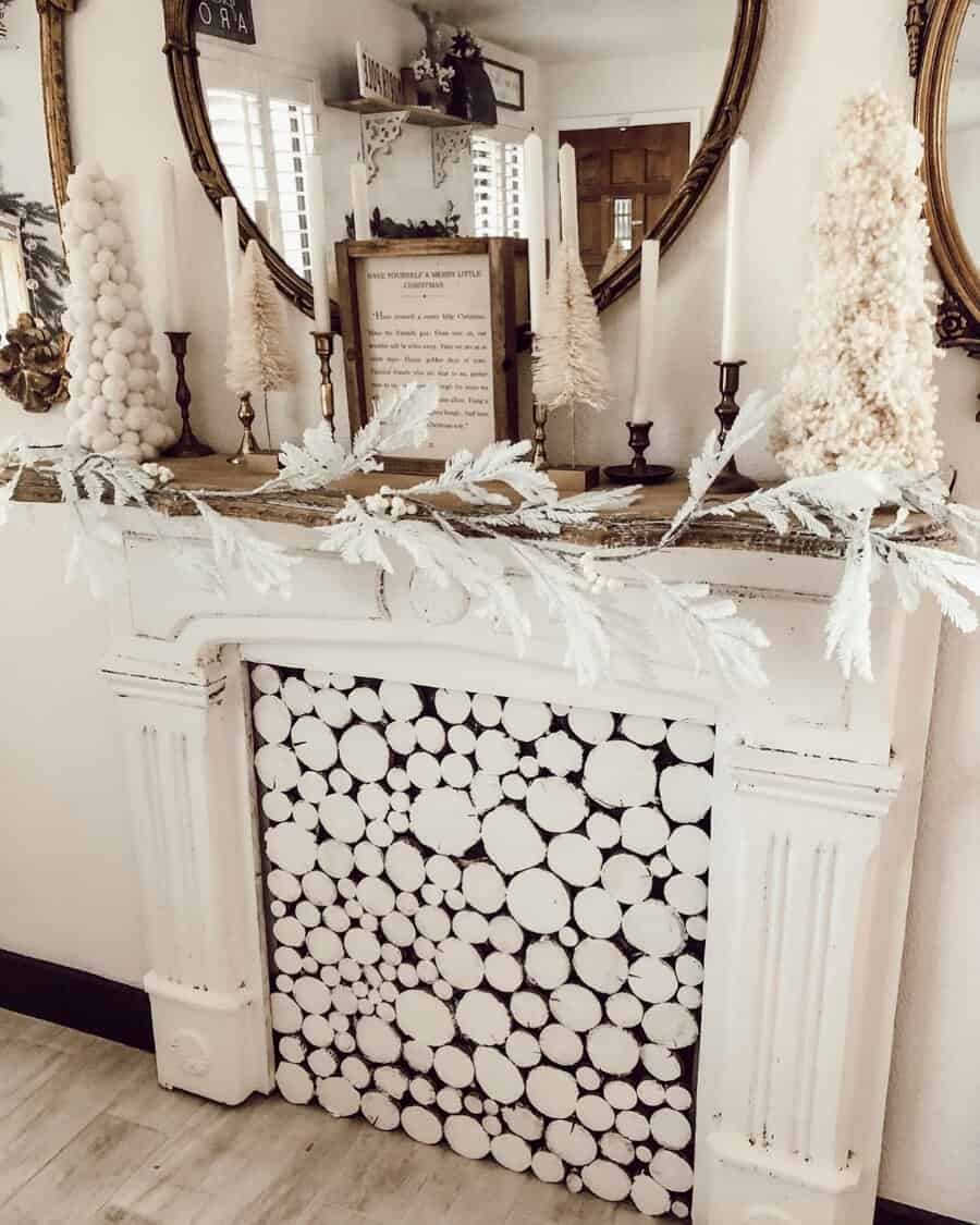 White rustic decorative fireplace with holiday decor, including candles and trees