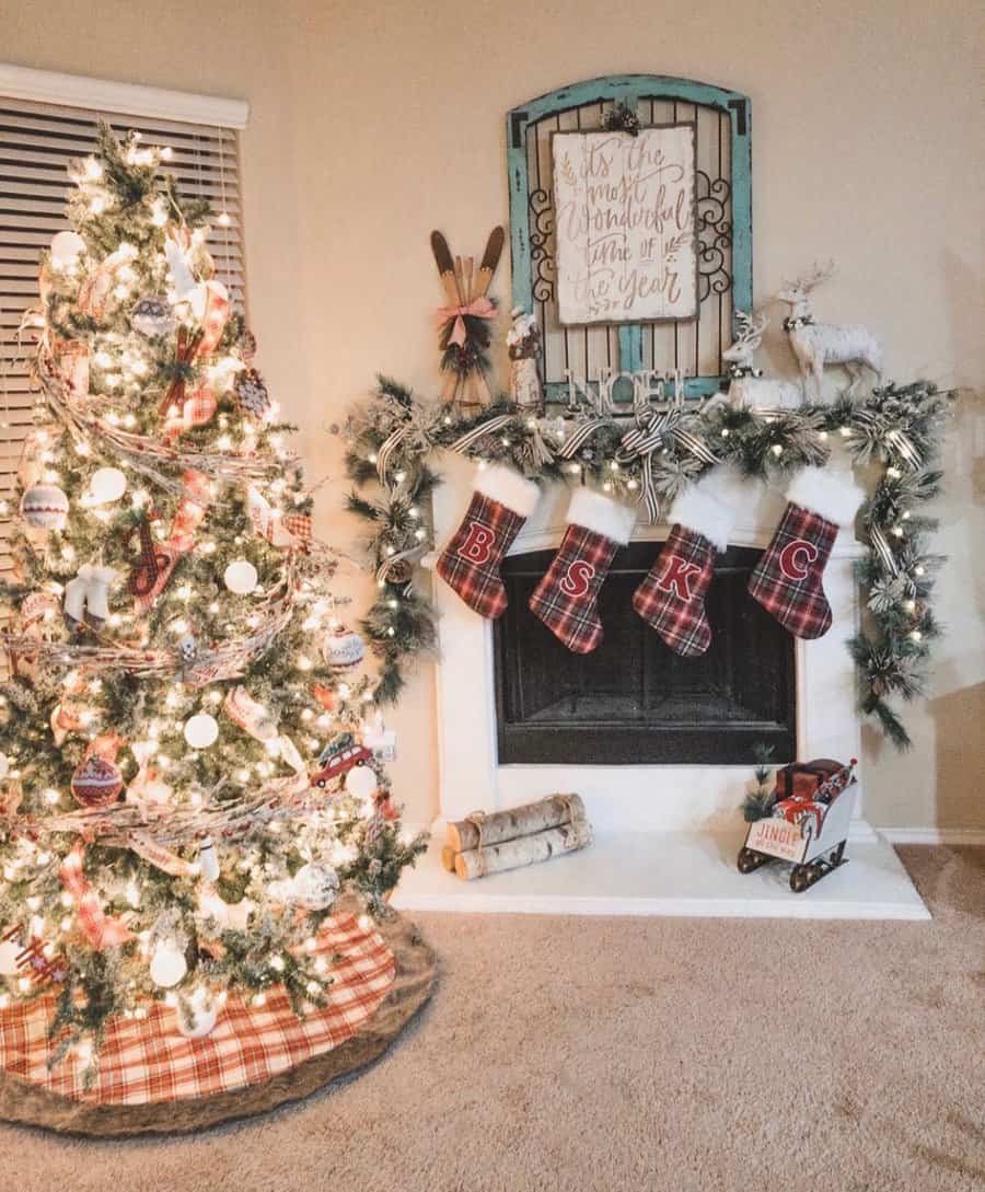 Christmas tree and stockings by a decorated fireplace with festive ornaments