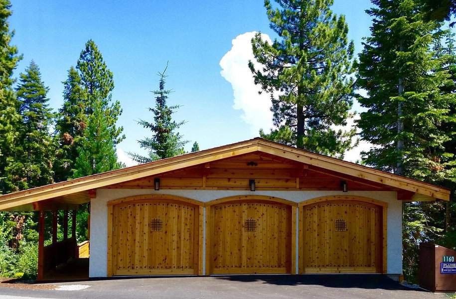 Cabin garage with ornate wooden doors in forest setting