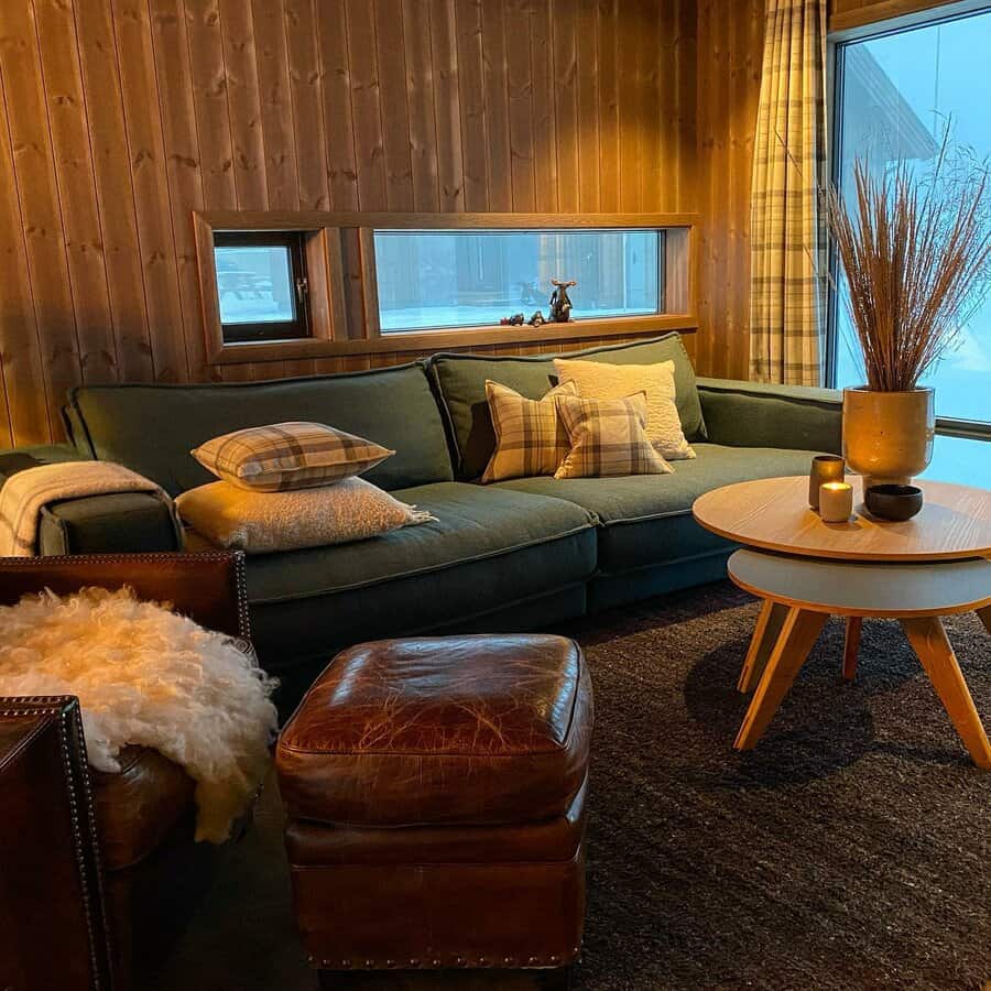 Cozy cabin living room with wood paneling and green sofa