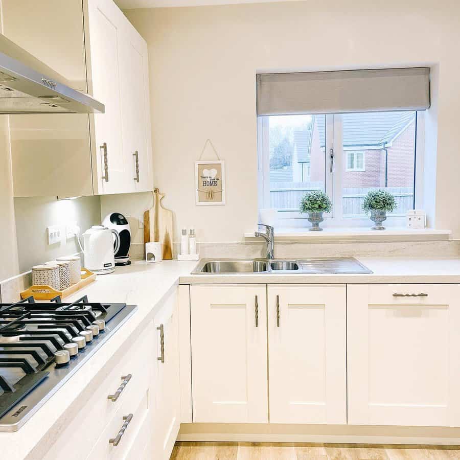 White kitchen with grey roman shade