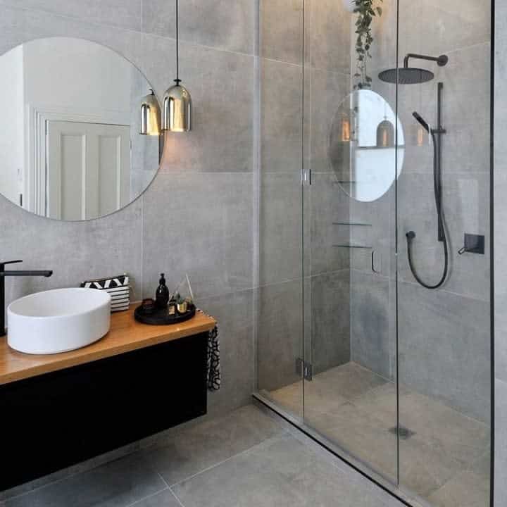 Sleek bathroom with round mirror and glass shower