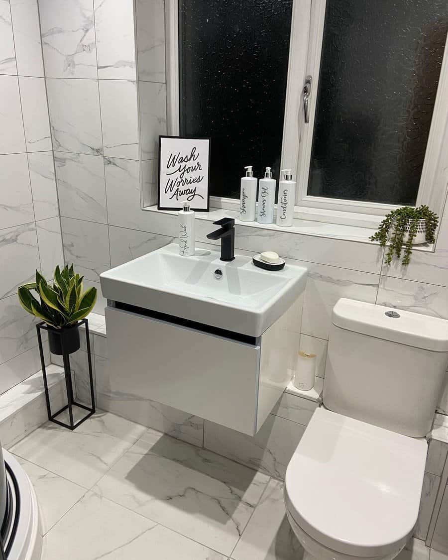 Small modern bathroom with a sink and motivational quote