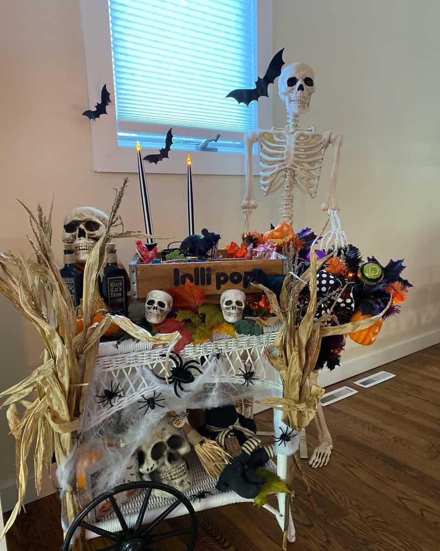 Halloween-themed skeleton and skull display with decorations on a cart