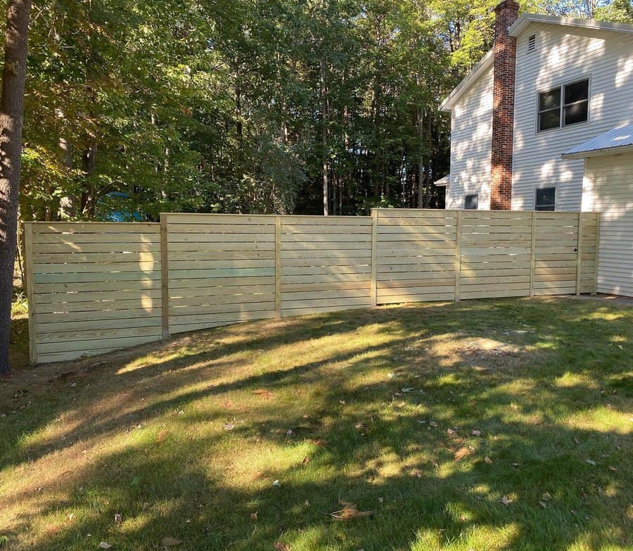 A residence with a fence under construction in the foreground