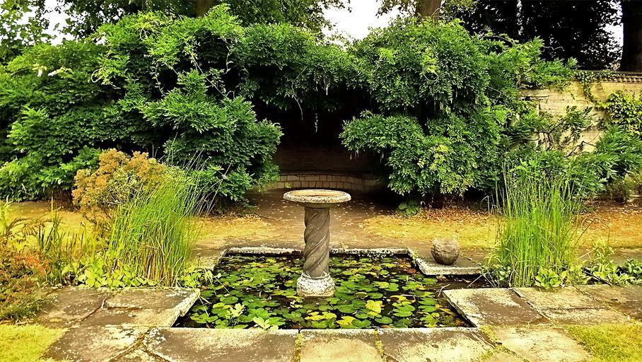 Historic garden pond with sundial and lily pads