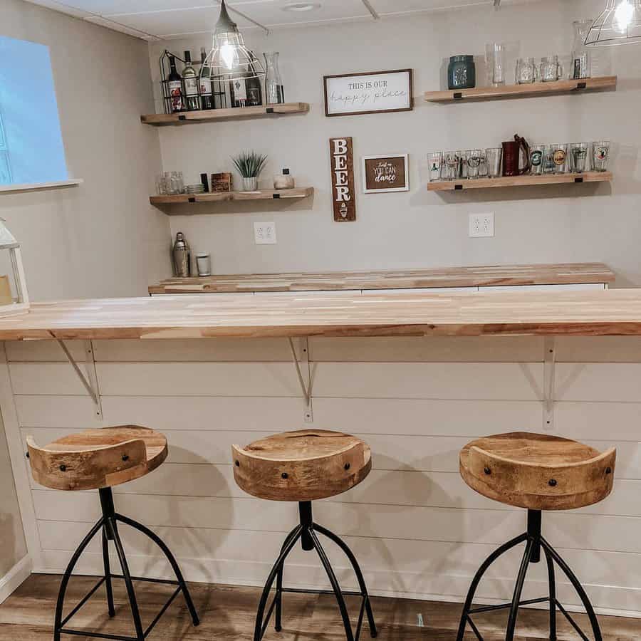 Rustic home bar with natural wood stools and floating shelves