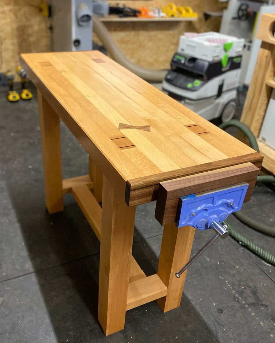 Wooden workbench with blue vise in a workshop