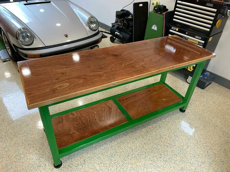 Glossy wooden workbench with green frame in a garage