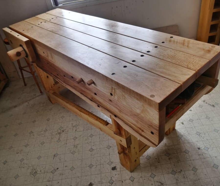 Rustic wooden workbench with tool slots and vise