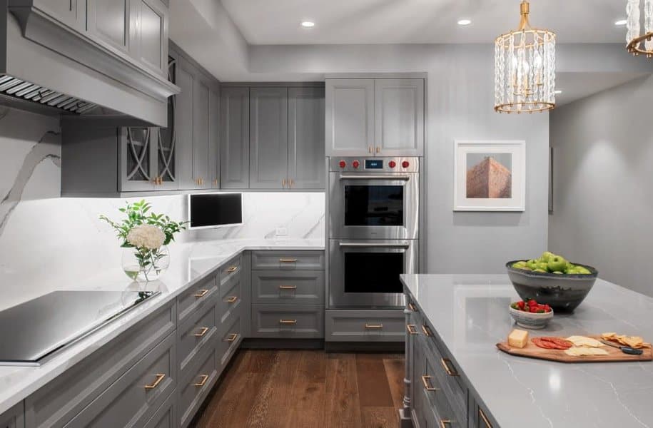 Sleek gray cabinets and elegant marble island with chandelier