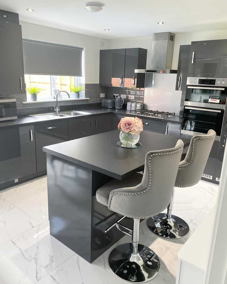 Modern kitchen with black island and grey chairs