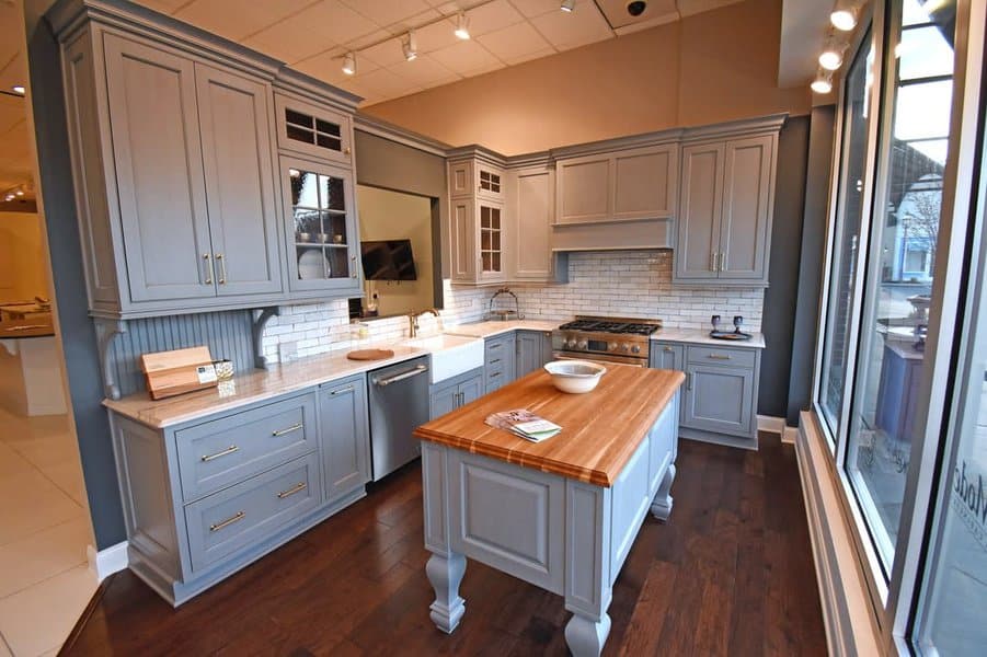 Bright kitchen with wooden floors and gray wooden cabinets