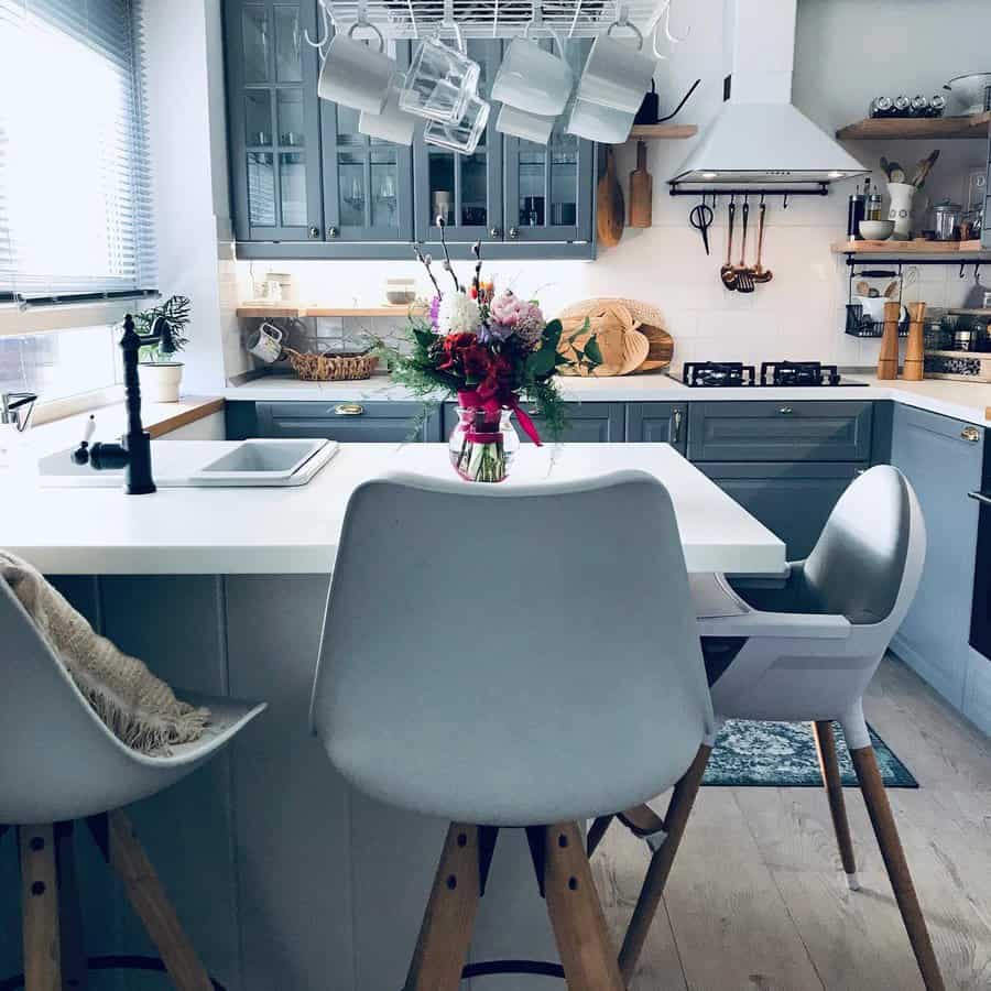 Sleek kitchen with white countertop and gray chairs