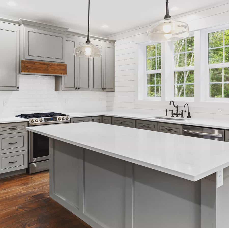 Minimalist kitchen with white countertop and a gray island