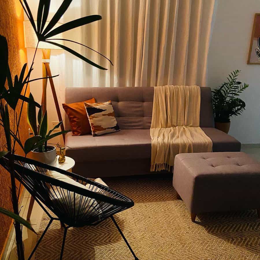 Warm and cozy tiny living room with soft lighting, a neutral sofa, earthy-toned pillows, a woven rug, and lush greenery for a relaxing ambiance