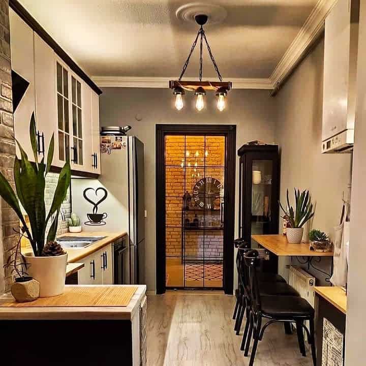 Warmly lit narrow kitchen with bar seating and brick details