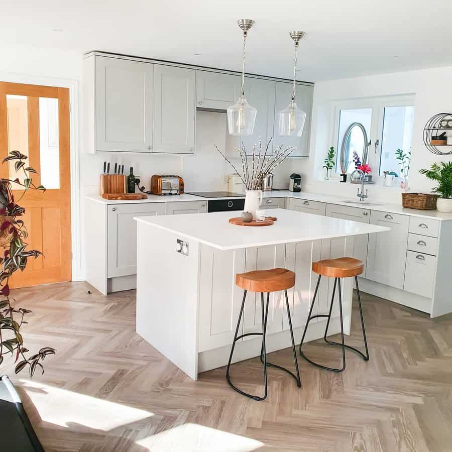 Sunny kitchen with white island and bar stools