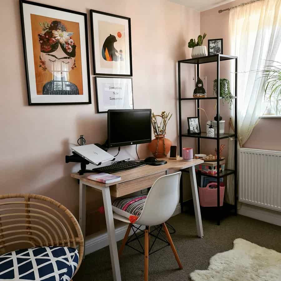 Home office with a wood desk, computer, chair, shelves with decor, wall art, and a window with sheer curtains. Cozy and organized space