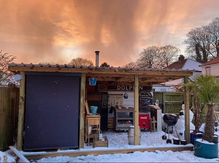 Outdoor bar with fiery sky backdrop and snow on the ground