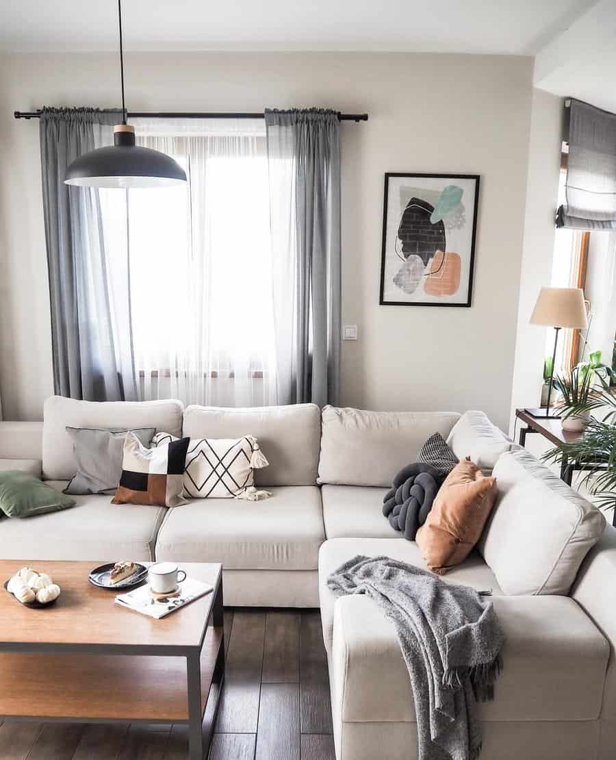 Cozy living room with a white sectional sofa, coffee table, and wall art above