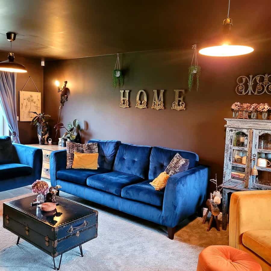 Cozy living room with blue sofas, eclectic decor, and "HOME" sign on the wall