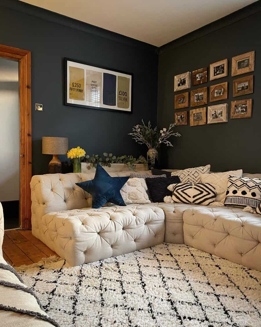 Cozy living room with a tufted sofa, pillows, photos on the wall, and a patterned rug