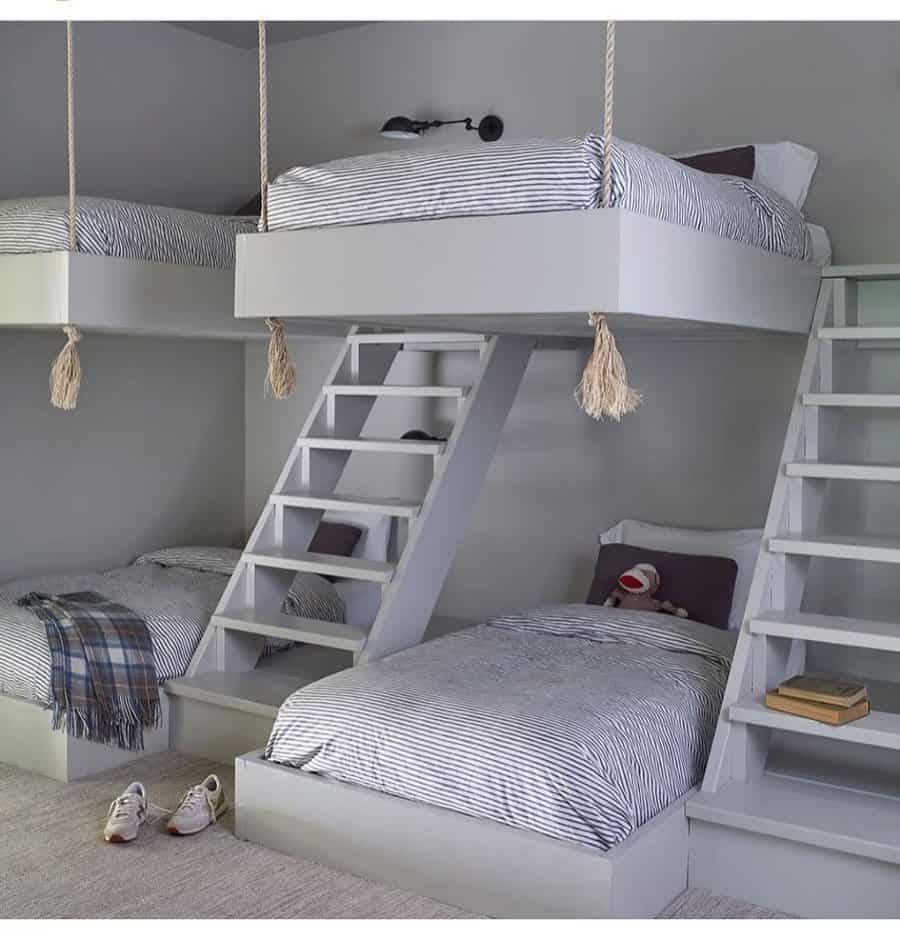 Smart space-saving bunk bed design with four beds, suspended upper bunks, and built-in angled ladders for a sleek shared bedroom setup