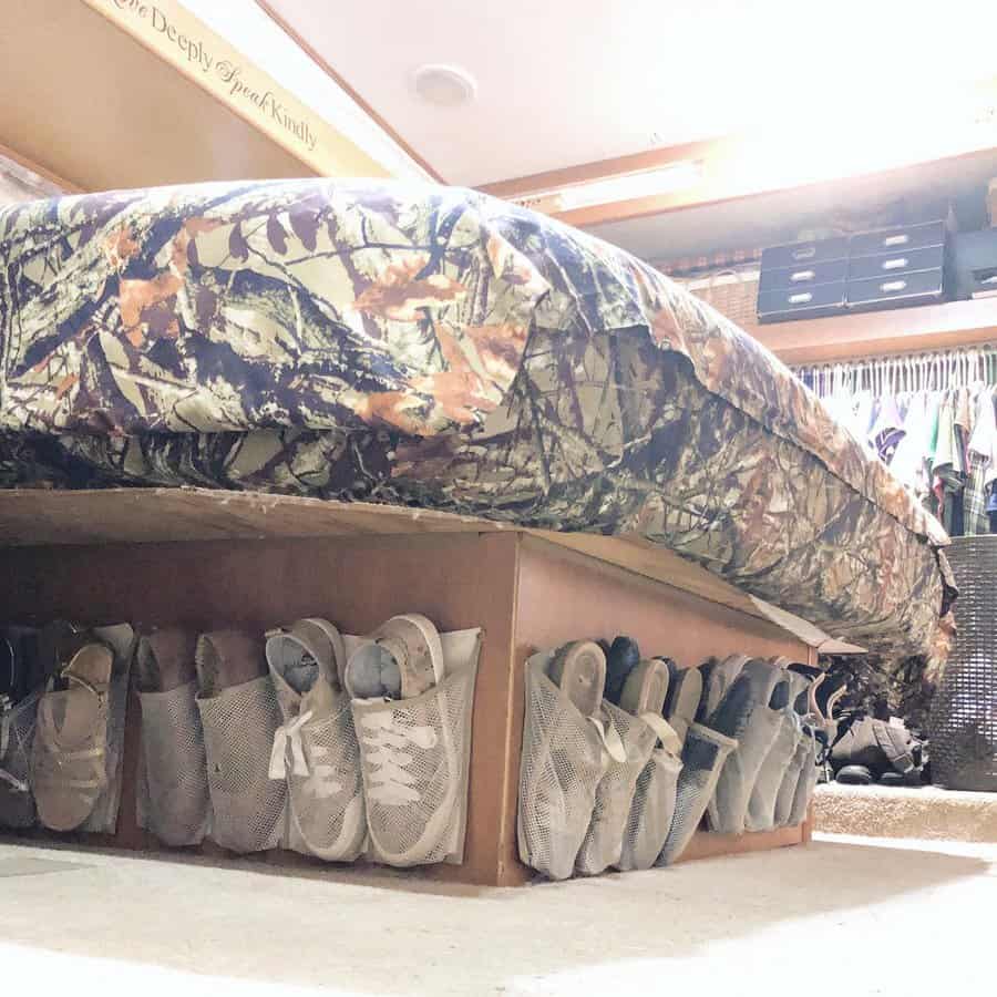 RV bedroom with under-bed shoe storage using mesh pockets, maximizing space while keeping footwear organized and accessible.