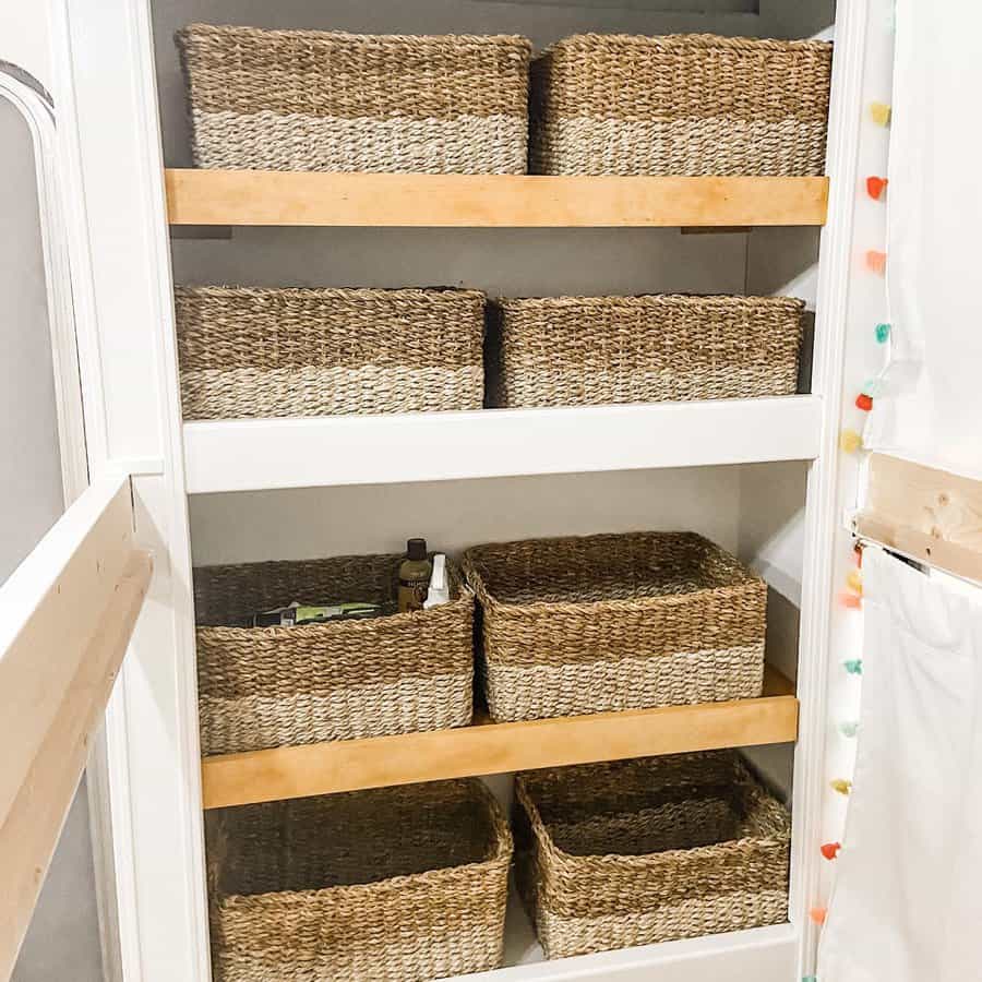 Shelving unit with wicker baskets in each compartment, surrounded by a colorful string of lights