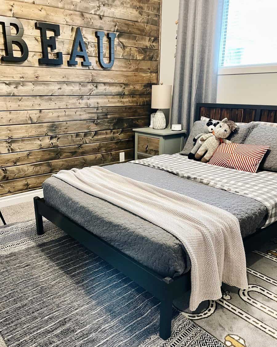 Bedroom for kids featuring a dark shiplap wall and oversized alphabet art