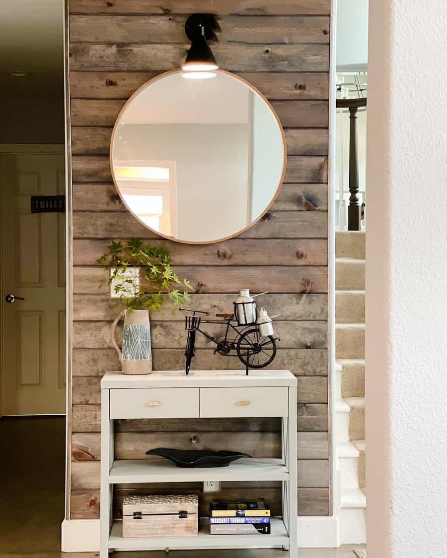 Hallway with rustic shiplap wall and round mirror