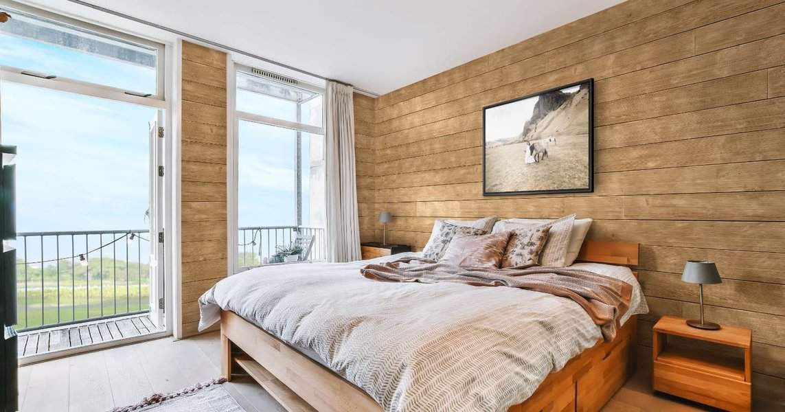 Bedroom with balcony view and wooden shiplap walls