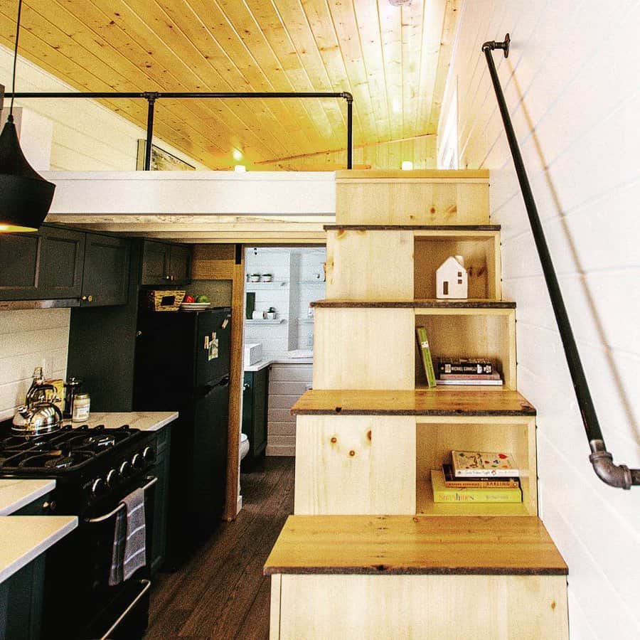 Kitchen with wooden staircase leading upstairs to a loft