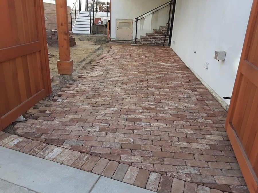 Red brick pathway leading to a building's side entrance