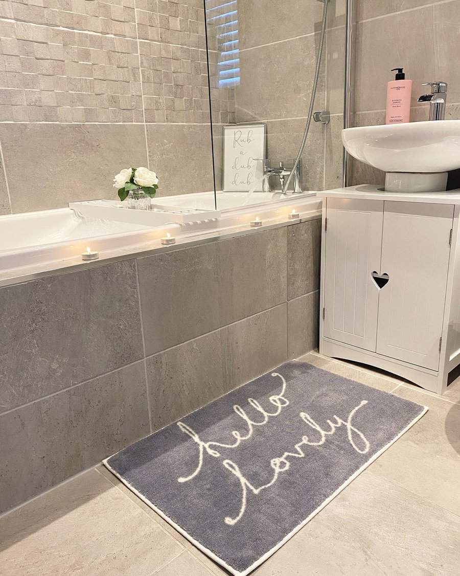 Inviting bathroom with mat and soft grey tiles