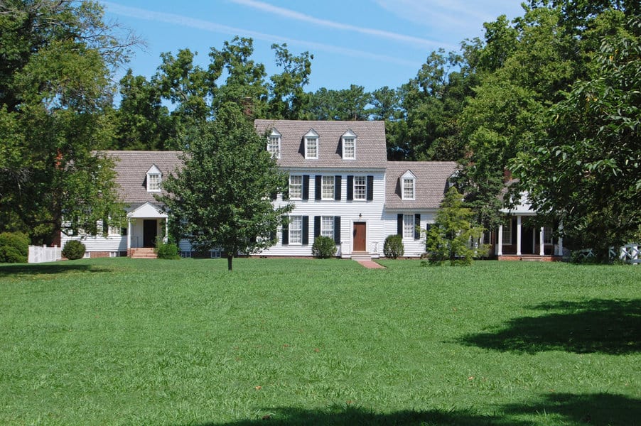 Colonial house with grass lawn