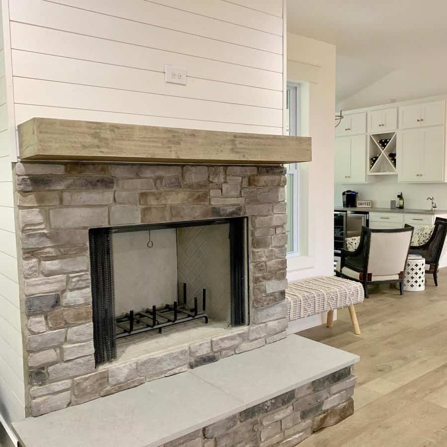 A rustic stone fireplace with a simple wooden mantel, creating a cozy atmosphere with clean lines and a minimalist design