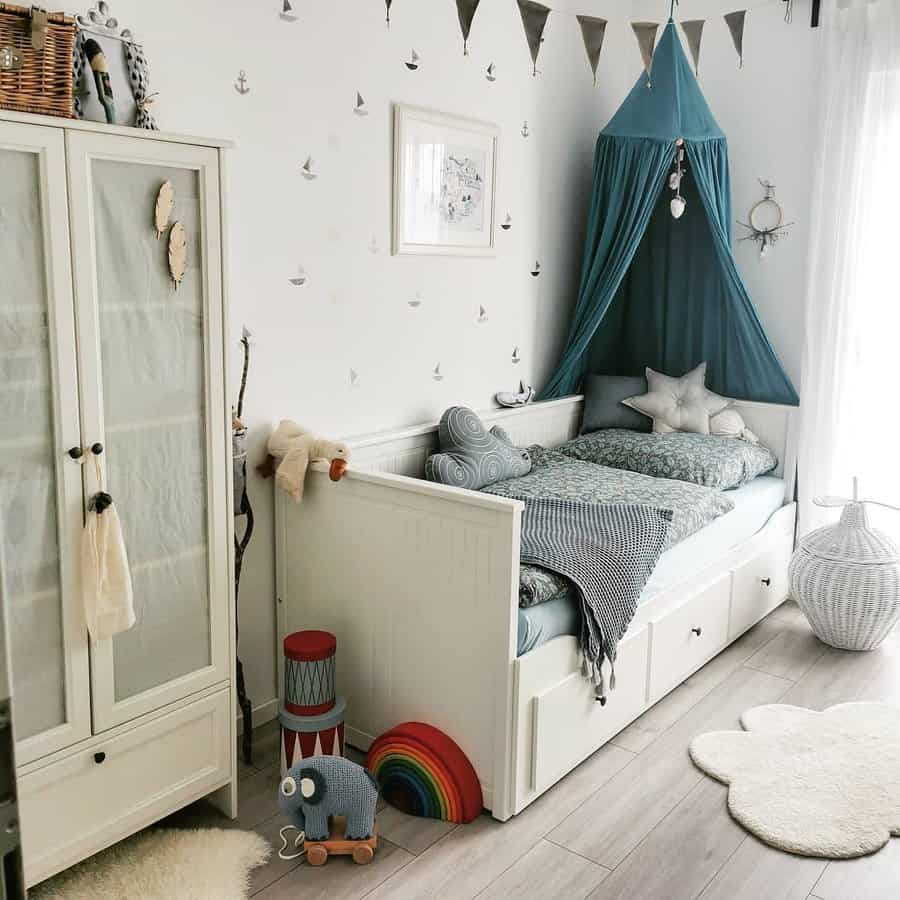 Charming kids' room with a white storage daybed, nautical-themed decor, and a cozy canopy, creating a playful and functional sleeping space