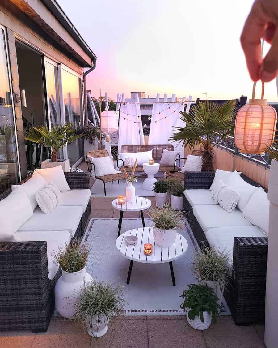 Boho-chic rooftop balcony with cozy seating, string lights, lush greenery, and soft textiles, creating a dreamy sunset retreat