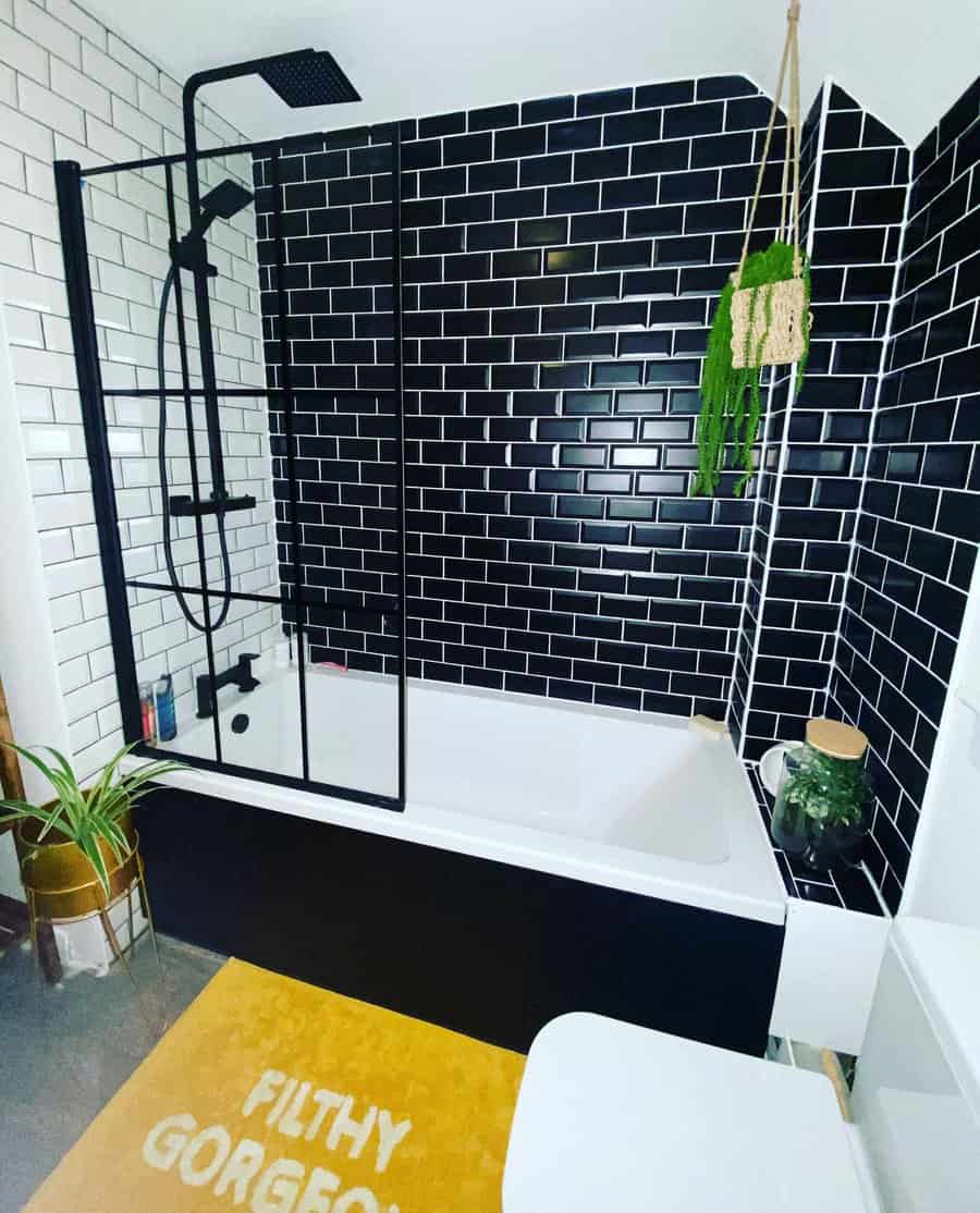 Modern bathroom with contrasting black and white tiles and bath mat