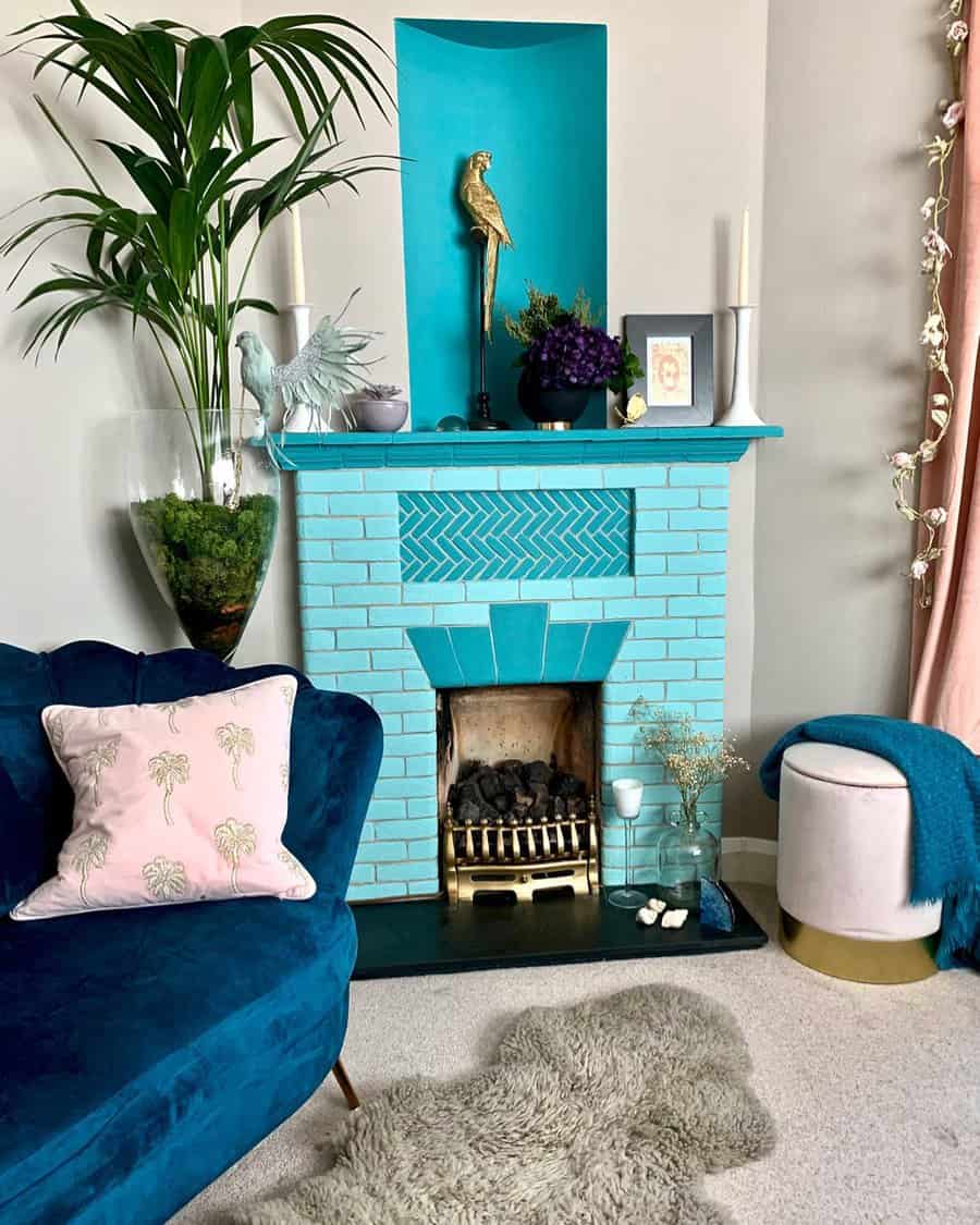 Living room with a bright blue brick fireplace, blue sofa, pink pillow, plant, decorative items, and a cozy atmosphere