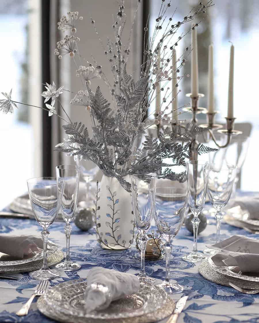 Elegant table setting with silver decor, glassware, and a blue and white tablecloth