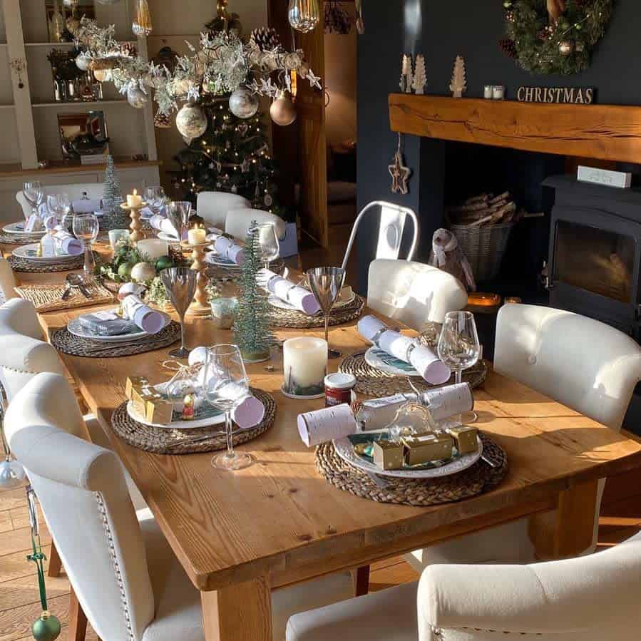 Festive Christmas dining table setup with decorations and a Christmas tree in the background