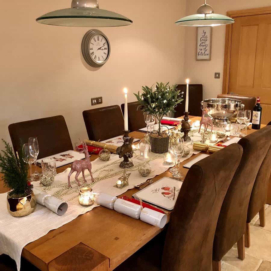 A cozy dining table set for a festive dinner with candles, decorations, and wine